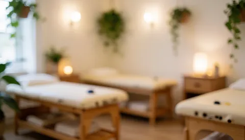 Calm reflexology treatment room featuring wooden beds, hanging plants, and warm lighting, ideal for text or logo placement