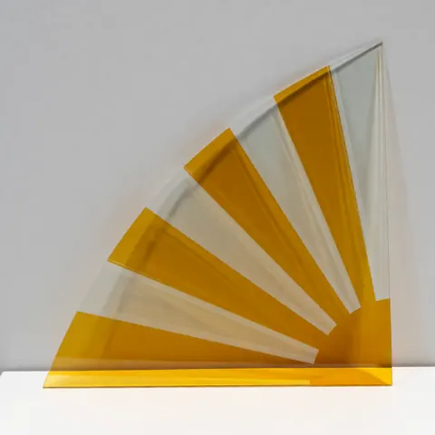 A close-up view of a decorative radial glass panel featuring yellow and transparent sections, suitable for modern interior design and commercial applications.