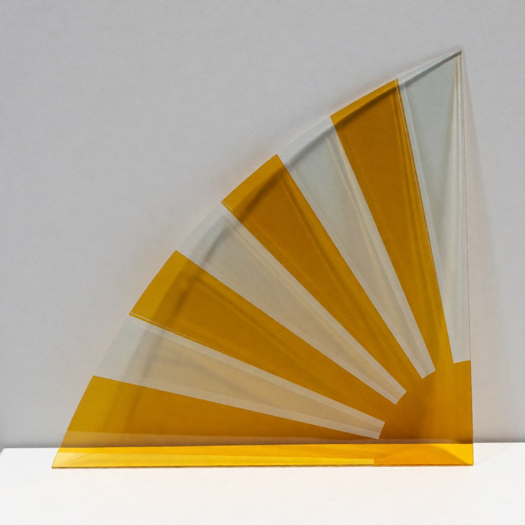 A close-up view of a decorative radial glass panel featuring yellow and transparent sections, suitable for modern interior design and commercial applications.