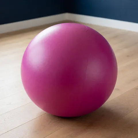 A magenta latex exercise ball used for prenatal care, childbirth, and maternal massage therapy to support relaxation and physical wellness.