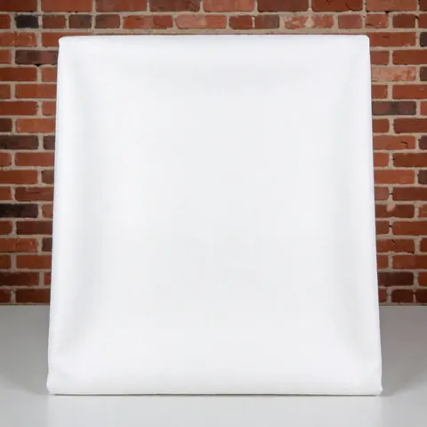 Close-up view of a white cotton textile fabric folded neatly on a surface, showcasing its soft texture and clean appearance for product display.