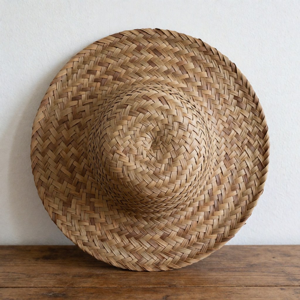 A woven palm hat displayed against a rustic wooden wall, highlighting natural texture and artisanal craftsmanship for product decoration.