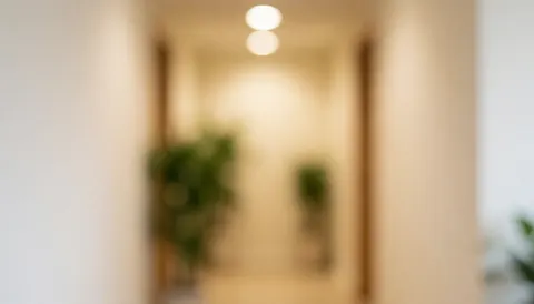 Softly blurred background featuring beige walls, green plants, and warm lighting suitable for spa and wellness text overlays