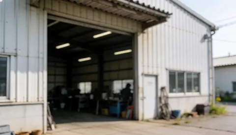 Interior of a metalworking shop with an open door, corrugated metal walls, natural lighting, and blurred background suitable for text overlay