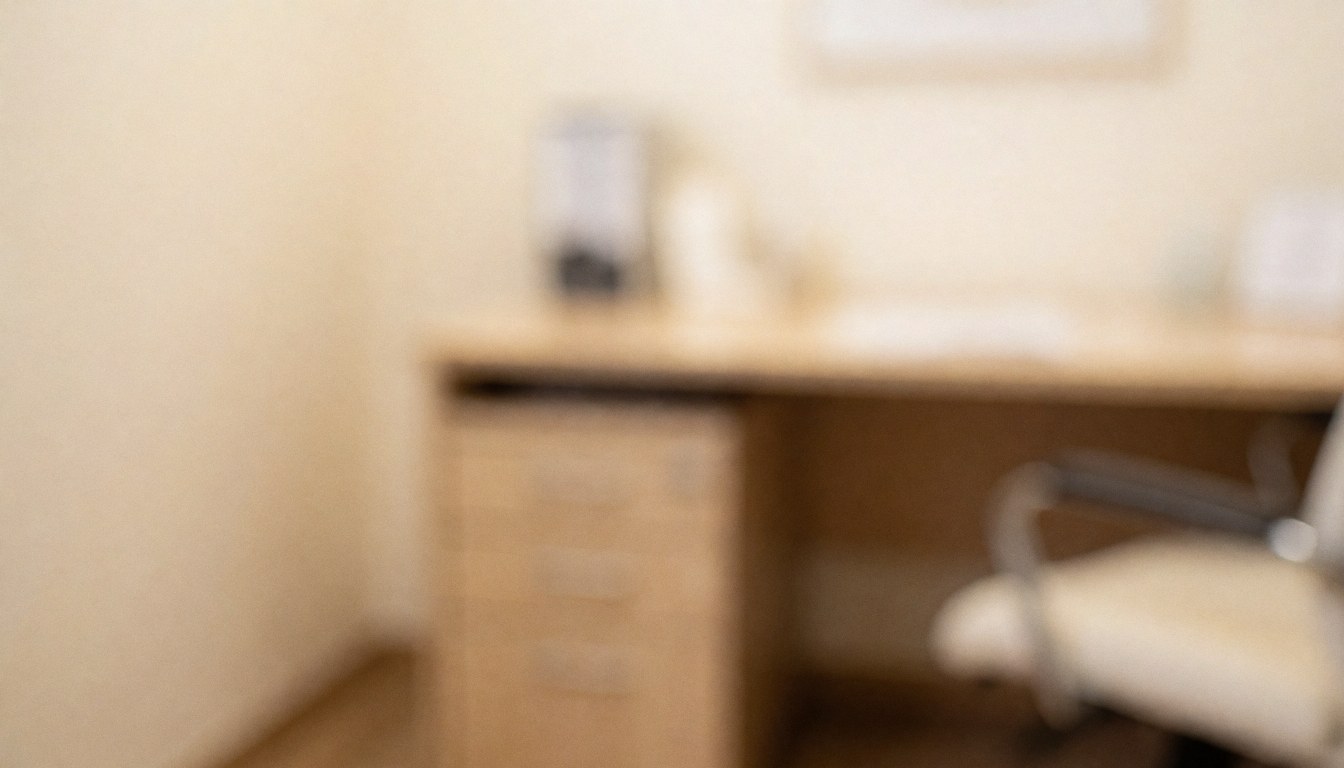 Soft focus clinical office with desk, filing cabinet, and chair in warm beige tones, ideal for hypnotherapy text overlays
