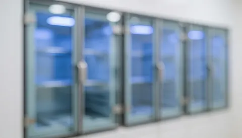 Rows of UV sterilization cabinets emitting blue light in a clean clinical setting, serving as a minimalist background for medical text.