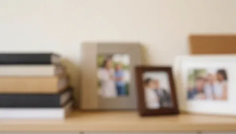 Soft blurred background with photo albums and frames on a shelf, ideal for graduation photography business text overlays