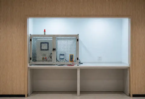 Microwave test zone featuring a safety box, meters, and light wood walls in a clean space prepared for technical verification.