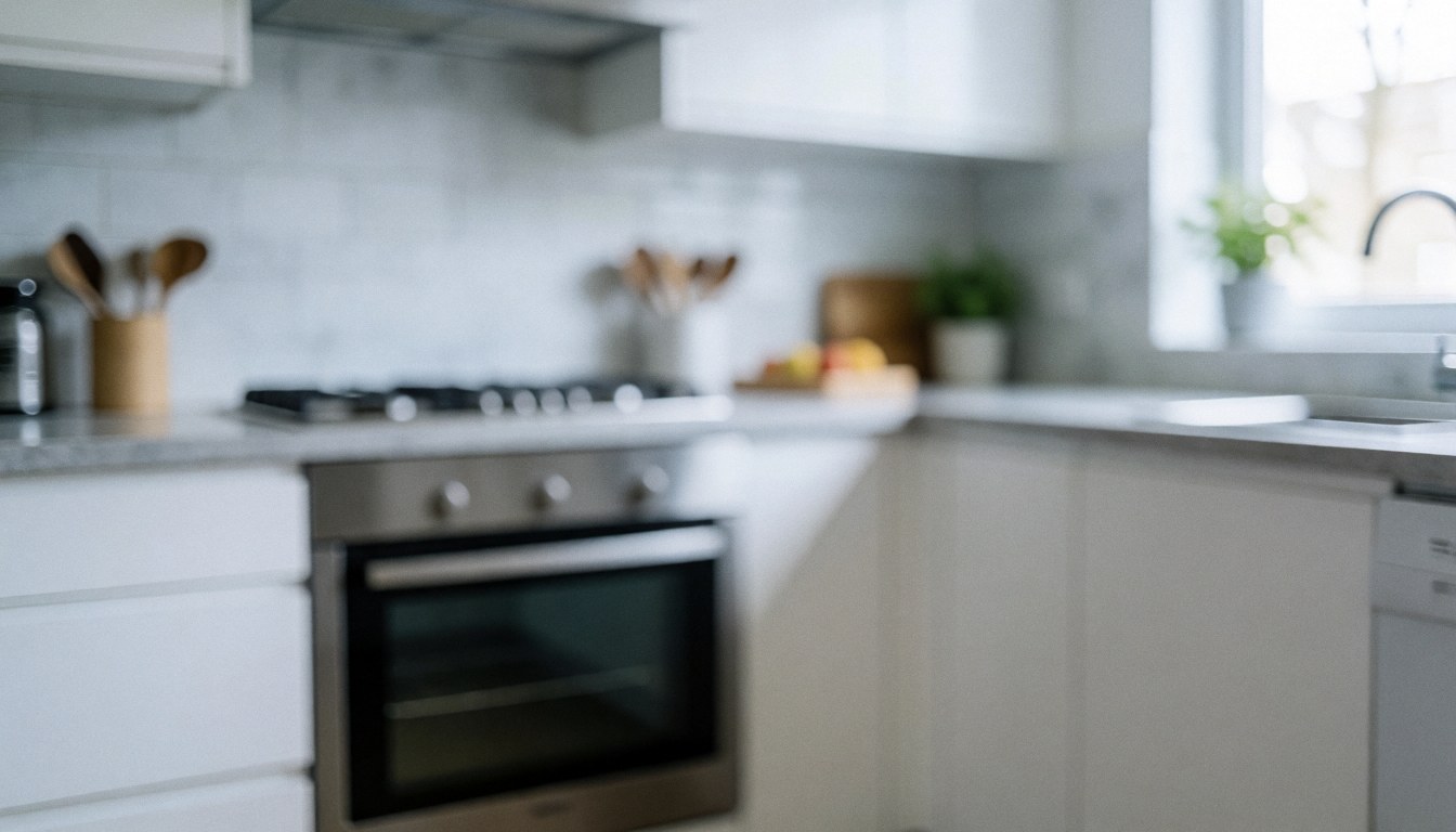 Soft focus background of a modern kitchen featuring a stainless steel oven, white countertop, and natural light, suitable for service text overlays.