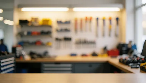 Soft focus background of a repair shop featuring tool shelves and wall-mounted equipment illuminated by warm lighting.