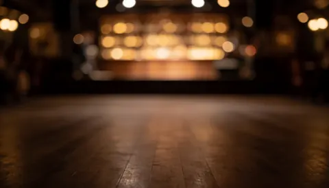 Wooden floor background with warm blurred lights, ideal for dance event promotional text.
