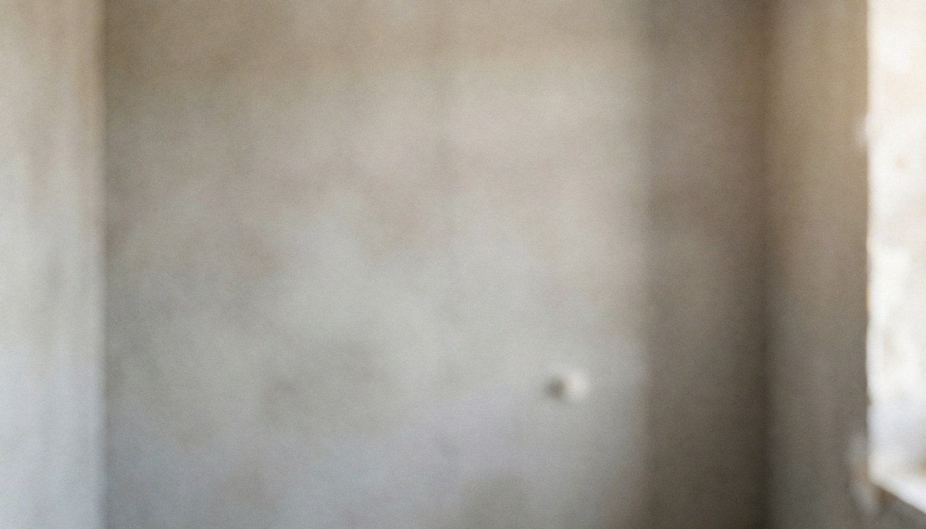 Gray cement walls in a remodeled bathroom with soft diffuse lighting, ideal for text overlay and bathroom installation services