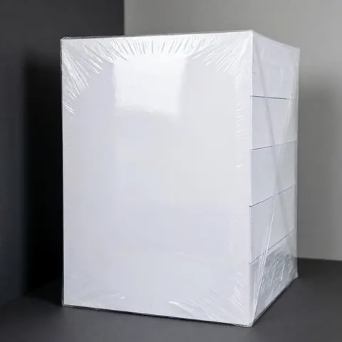 A stack of white A4 paper wrapped in clear plastic on a gray background, ideal for office or school stationery products.