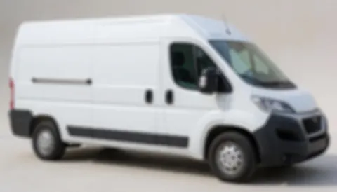Neutral background with a blurred white van, ideal for commercial text. Smooth surface, soft lighting, no visible text or logos.