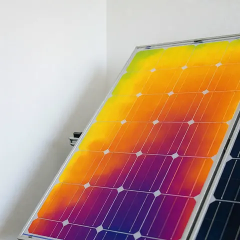 Photovoltaic panel displaying a thermal image with a color gradient showing temperature distribution for efficiency diagnosis