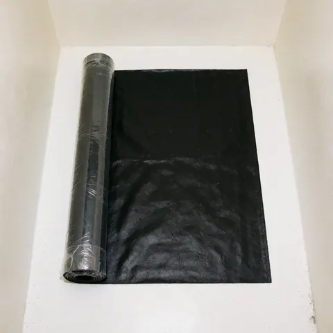 Black waterproofing membrane unrolled on a white surface, ready for installation in commercial construction projects.