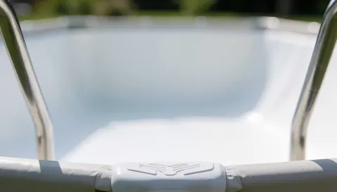 Clean metal pool railing against a white liner backdrop, providing a neutral and soft-lit background ideal for business text overlays.