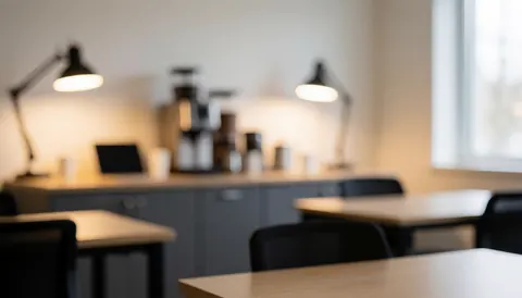 Warm and relaxed programming classroom background featuring desks chairs lamps and a coffee station ideal for studying