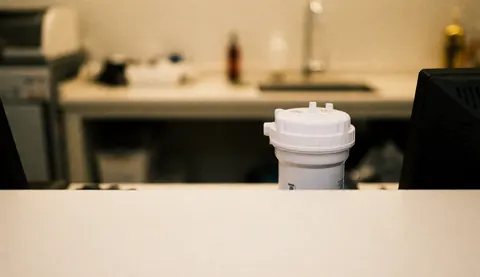 White water filter resting on a workshop counter with a blurred background of warm, dim lighting suitable for text overlay