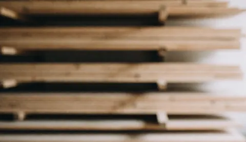 Soft focus background of stacked wooden planks with warm lighting, ideal for interior design service text overlays
