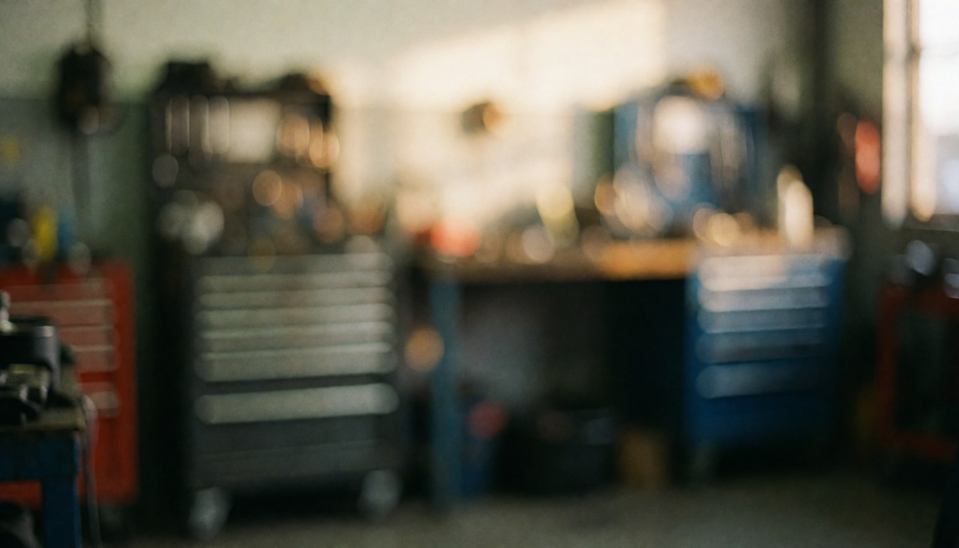 Out of focus repair shop background featuring tool drawers, work tables, and warm lighting, suitable for service text overlays