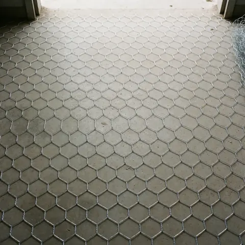 Top view of galvanized wire mesh laid out on a concrete surface for construction or roof repair projects