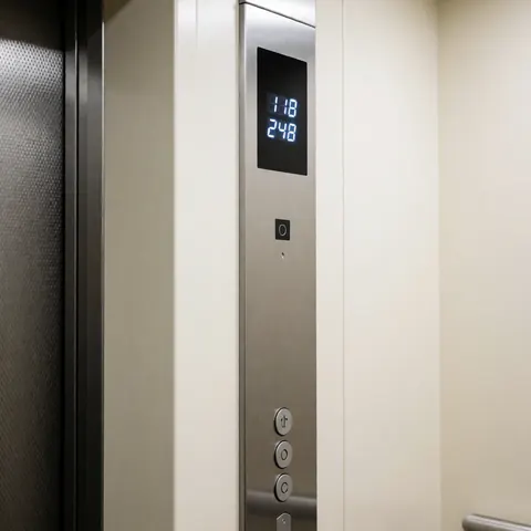 Modern elevator control panel mounted on the wall next to the door, featuring a digital display showing real-time weight data in a clean and functional design.