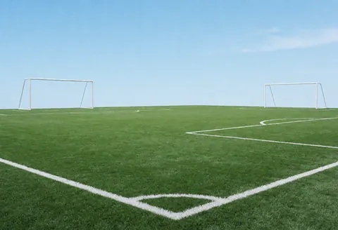 Green artificial turf soccer field with white boundary lines and two white goals at each end, suitable for a sports club.