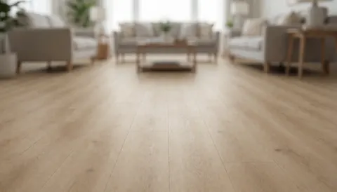 Close-up of beige vinyl plank flooring with blurred furniture in the background, providing a clean surface for commercial text overlays.
