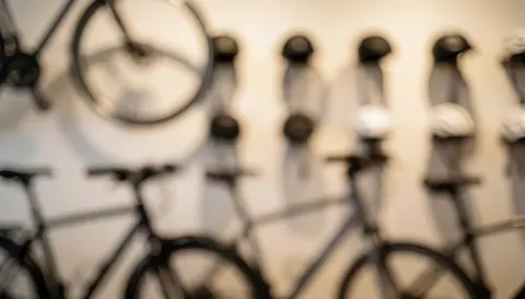 Soft blurred background of mountain bikes and cycling helmets in a store, ideal for advertising text overlays
