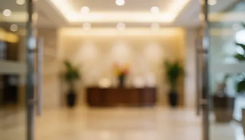 Softly lit lobby entrance with warm ambient lighting, blurred reception tables, and elegant decor, ideal for commercial text overlays.