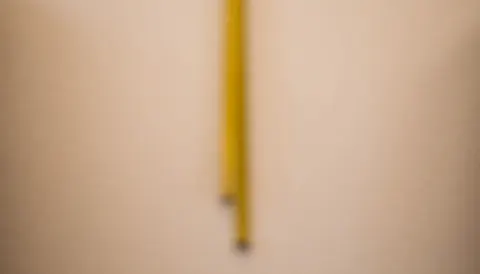 Soft blurred background of a tailor shop with a hanging yellow measuring tape, warm neutral tones, ideal for professional text and designs.
