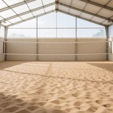 Round volleyball court with sand floor, net in center, and glass ceiling with natural light