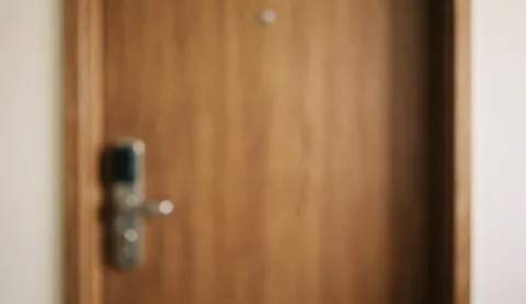 A close-up of a wooden door featuring a modern lock, set against a soft blurred background suitable for service text overlays.