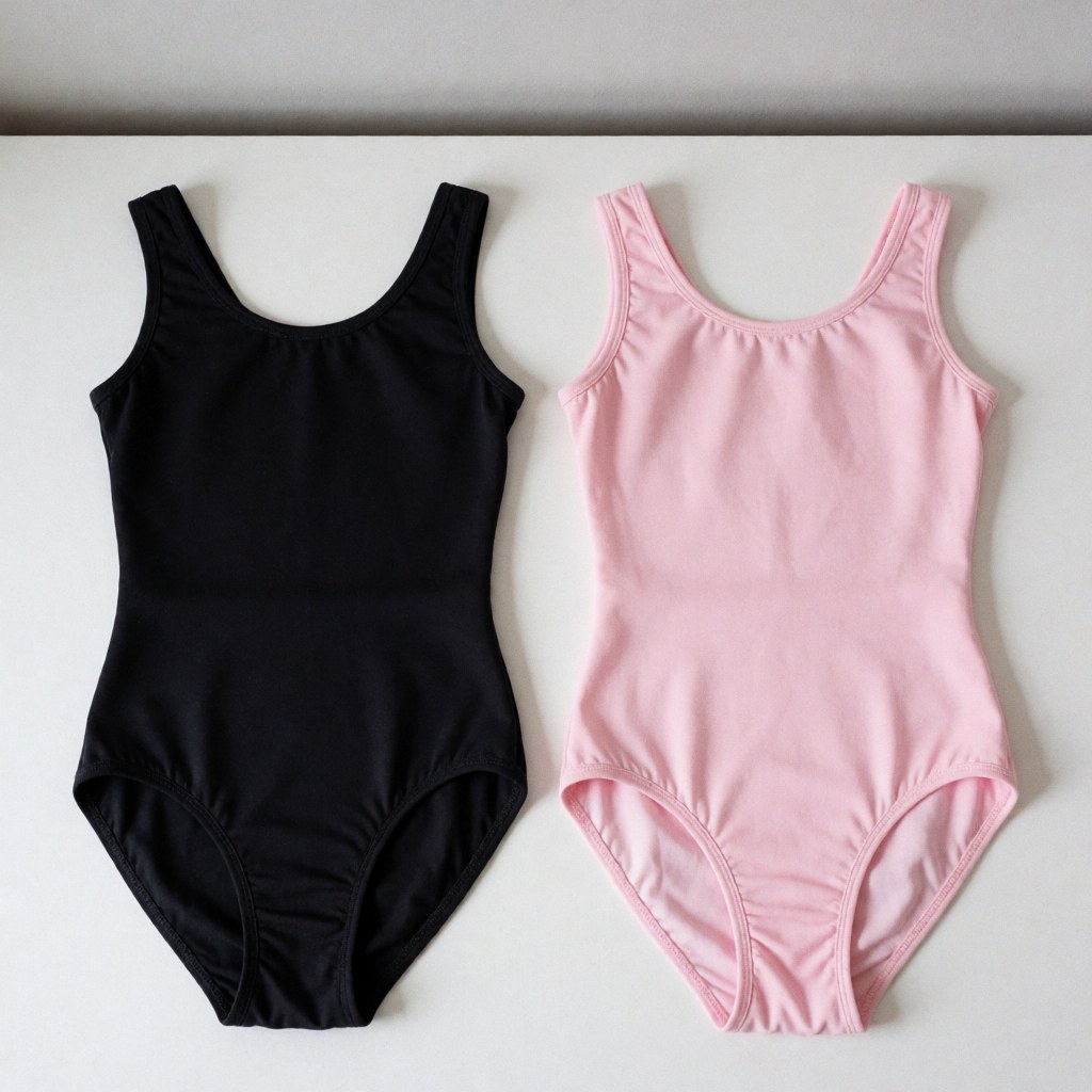 Flat lay of pink and black dance leotards on a white surface showing fabric texture and elasticity with soft lighting