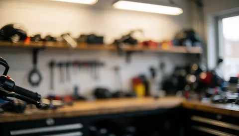 Blurred motorcycle workshop background with tools and parts, warm lighting and tidy atmosphere for text overlay