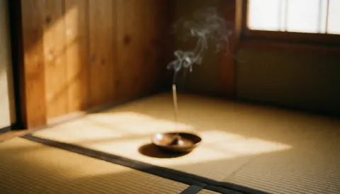 Incense burning in a metal box on tatami flooring with golden sunset light illuminating the wooden wall and floor, creating a relaxing atmosphere for shiatsu treatments.
