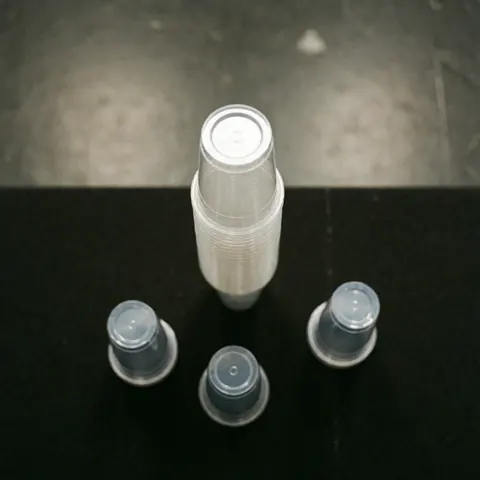 Stack of transparent plastic cups on a black matte surface, ideal for entertainment centers, events, and catering services.