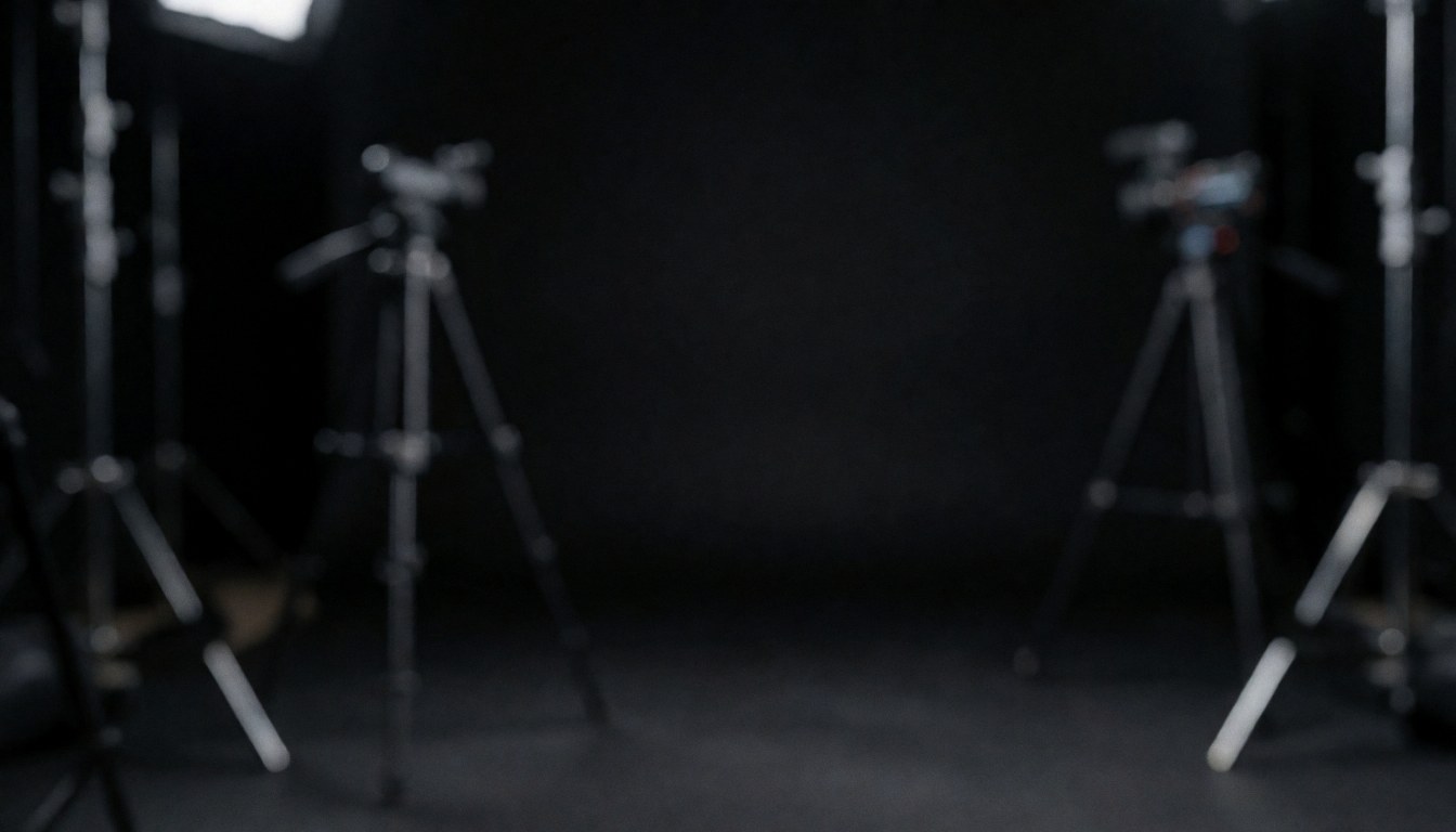 Dark studio background with blurred tripods and lights, ideal for text, professional and calm atmosphere