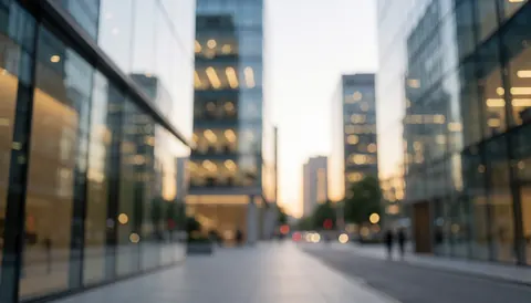Urban background featuring modern glass buildings and warm bokeh lights without people, ideal for commercial text overlays