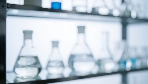 Out of focus glass jars on metal shelving with cool white light, suitable for corporate text backgrounds