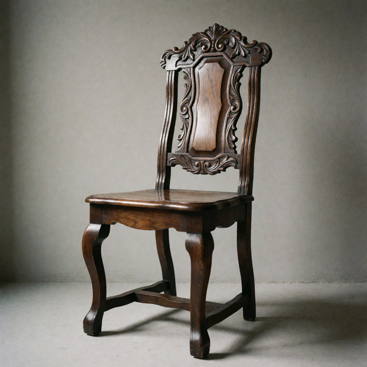 Restored dark wood chair featuring curved legs and a carved backrest, set against a neutral gray background.