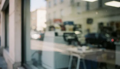 Soft focus background of an appliance repair shop window with street reflections and natural light, suitable for text overlay