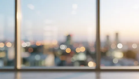 Blurred city view through an office window with warm lights and a serene atmosphere, suitable for text overlays.