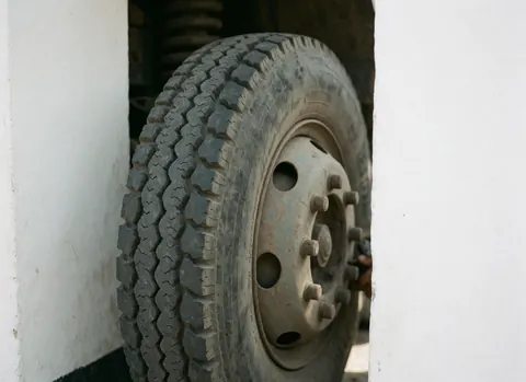 Close-up of a truck wheel featuring tire tread, white sidewalls, and metal and rubber details for logistics and transport businesses