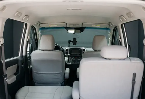 Clean and tidy ride-hailing vehicle interior featuring gray seats, a windshield phone mount, and a visible dashboard.