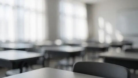 Empty modern classroom with tables and chairs, soft natural light, ideal background for robotics course text
