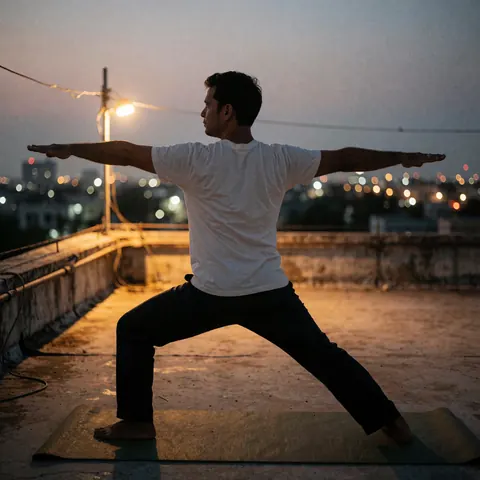 Silhouette of a man practicing yoga in warrior pose on a rooftop mat with blurred city lights in the background at dusk