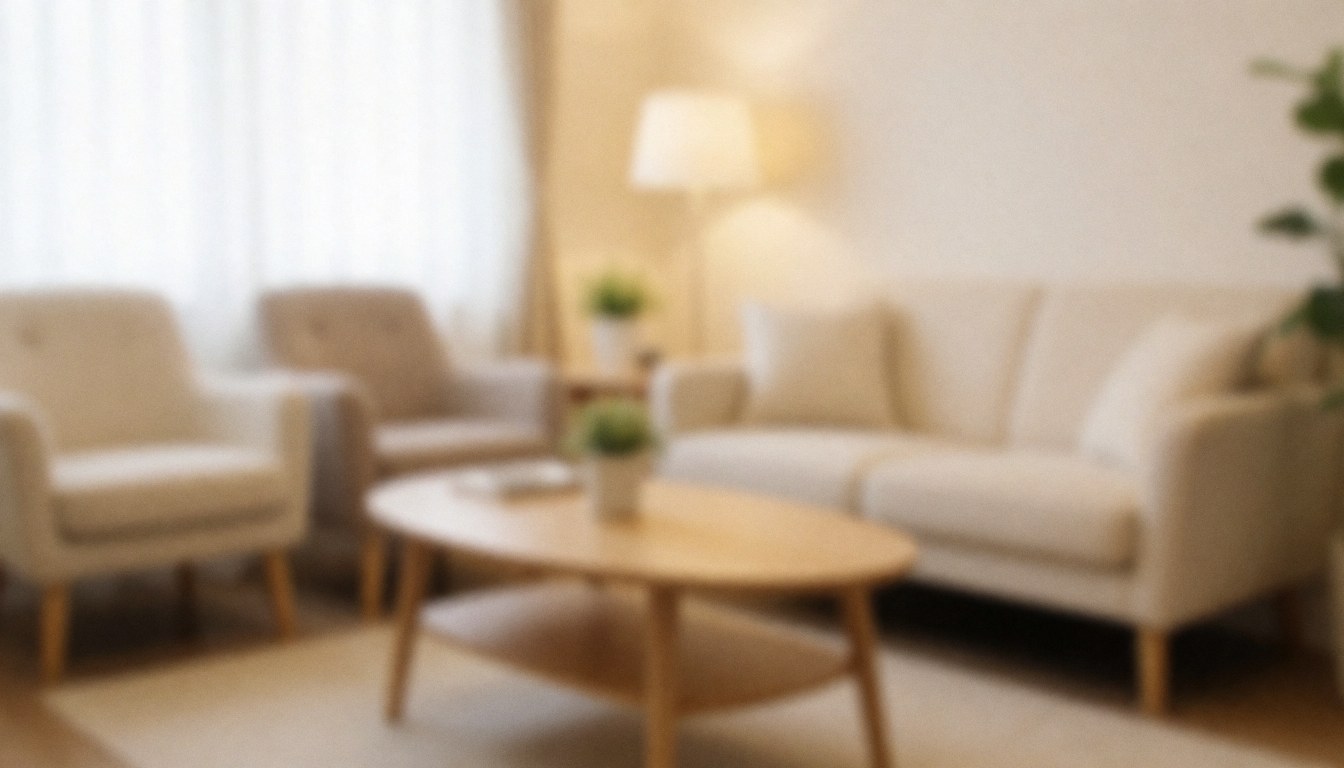 Warm waiting room interior featuring white sofas, a wooden coffee table, and a lamp, creating a relaxing atmosphere for a reflexology clinic.