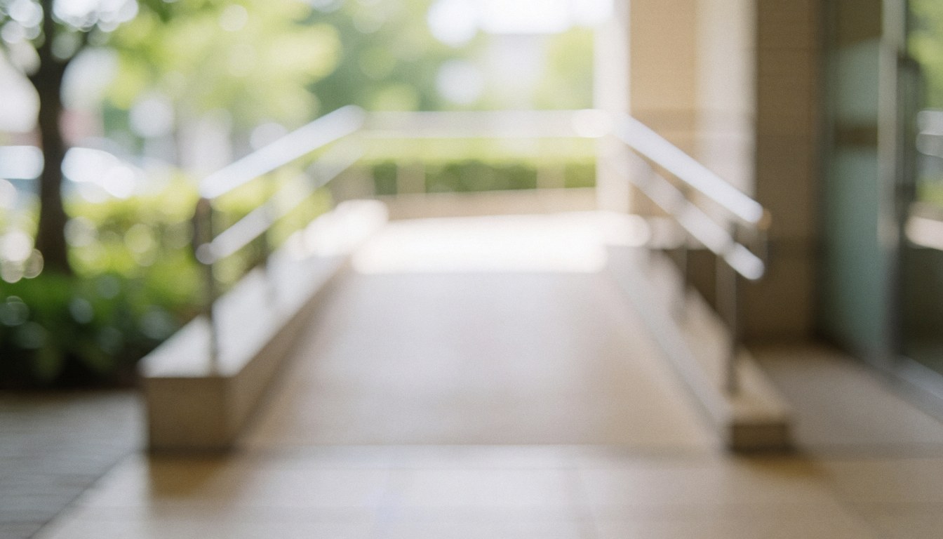 Accessible ramp with metal railings and soft natural light against a blurred vegetation background, suitable for commercial text overlays